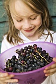 Mädchen hält eine Schüssel Weintrauben