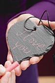 Hands holding chalk & a slate heart with the words I love you