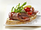Open sandwich of duck breast, rocket and cocktail tomatoes