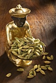 Gilded statuette with cardamom pods