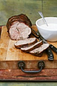 Rolled roasted veal, sliced, on a wooden board