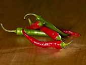 Red and green chillies on wooden background