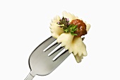 Two farfalle with sauce and thyme flower on fork