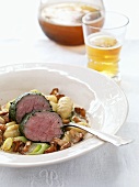Herb-wrapped veal fillet with ragout of chanterelles & gnocchi