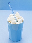 Tablets in a beaker with a straw