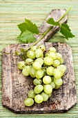Green grapes on old chopping board