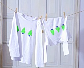 T-shirts with Christmas tree motifs hanging on washing line