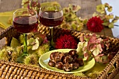 Hot chestnuts, dahlias and red wine on tray