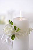 Burning candle with white rose