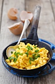 A pan of scrambled egg with spring onions