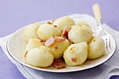 Potato dumplings with meat filling and fried bacon