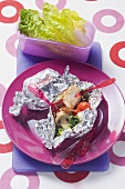 Pieces of chicken and vegetables cooked in foil