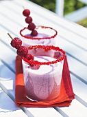 Two glasses of raspberry almond milk on garden table
