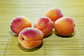 Five apricots on bamboo mat