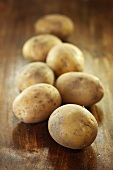 Several potatoes on wooden background