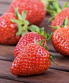 Fresh strawberries on wooden table (close-up)