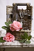 Small basket with garden tools, sage and roses