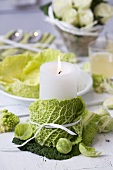 Winter table decoration: candle, savoy cabbage, Brussels sprouts