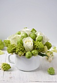 Arrangement of white roses, romanesco and Brussels sprouts