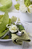 Place-setting with white rose and savoy cabbage leaves