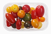 Assorted tomatoes in plastic container from above