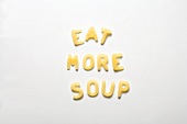 The words EAT MORE SOUP in alphabet pasta