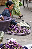 Frau verkauft Auberginen auf einem Markt in Burma