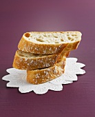 Three slices of baguette on white doilies