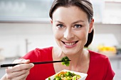 Woman eating Asian vegetables