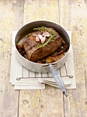 Roast beef with herbs and garlic in a pan