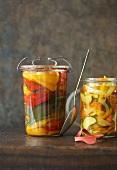 Pickled courgettes and peppers in oil, a jar of each