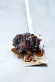 A piece of braised oxtail on a spatula