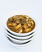 Beef stew in a soup bowl on a pile of bowls