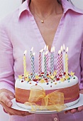 Geburtstagskuchen mit brennenden Kerzen