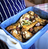 Roast chicken pieces with garlic in roasting dish