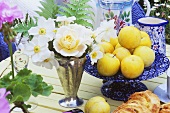 Rosen, Anemonen und frische gelbe Pflaumen auf einem Tisch