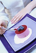 Young woman eating berry mousse