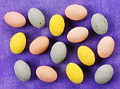 Small coloured Easter eggs on purple background