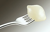 A pickled onion on a fork