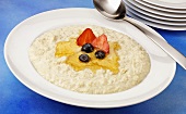 A plate of porridge with honey and fruit
