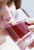 Young woman drinking a glass of cranberry juice