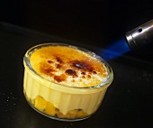 Crème brûlée mit einem Bunsenbrenner karamellisieren