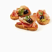 Crostini topped with Parma ham and olives