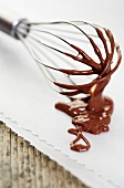 Whisk with chocolate icing
