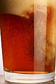 A glass of beer with a lot of head (close-up)