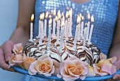 Birthday cake with burning candles and roses