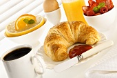 Frühstück mit Kaffee, Saft, Croissant und Früchten