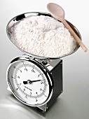 Flour and wooden spoon on kitchen scales
