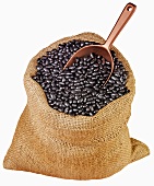 Black beans in jute sack with scoop