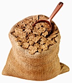 Whole-grain wheat flakes in jute sack with scoop